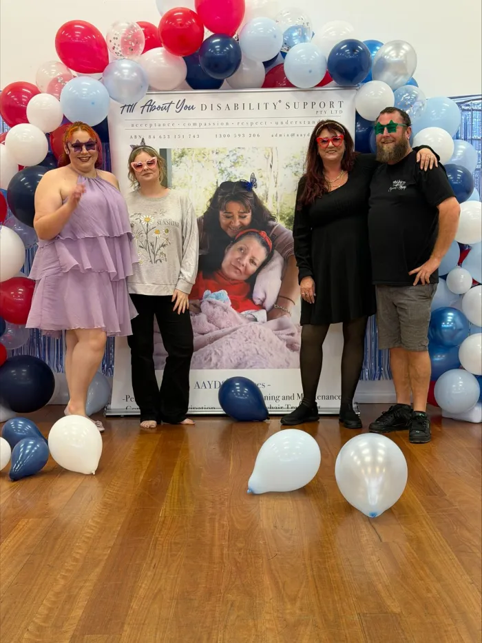 AAYDS team members and a participant in front of the company banner at an event