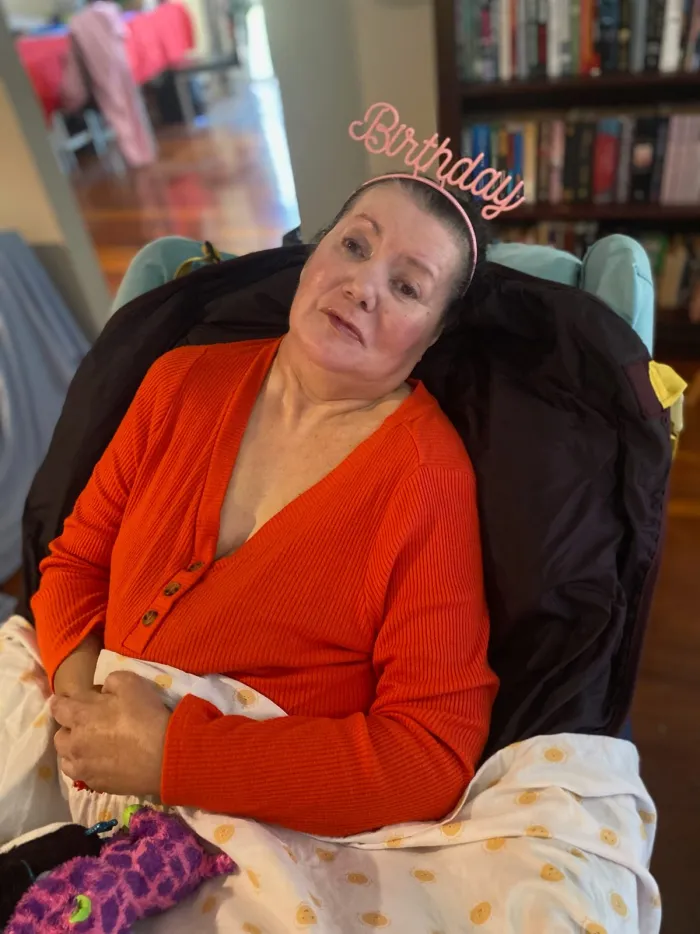 A participant wearing a birthday tiara, resting comfortably at home
