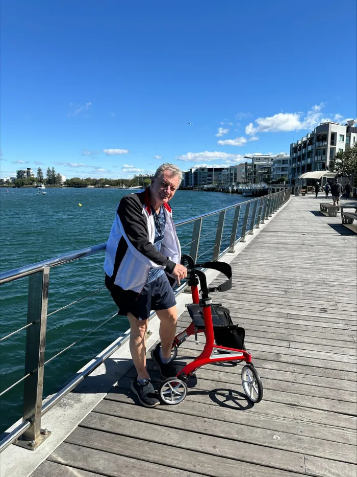 A participant out walking with a mobility frame along the Redcliffe waterfront