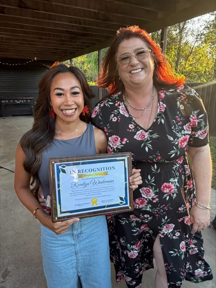 Two AAYDS team members with a staff recognition certificate