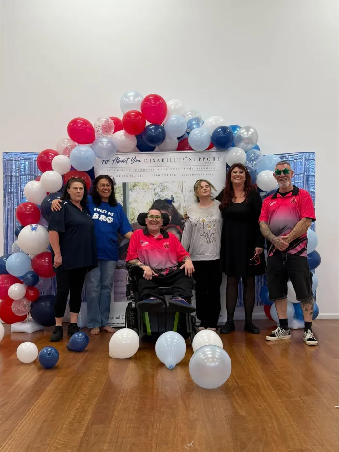 The AAYDS team and participants beneath a balloon arch at a community event