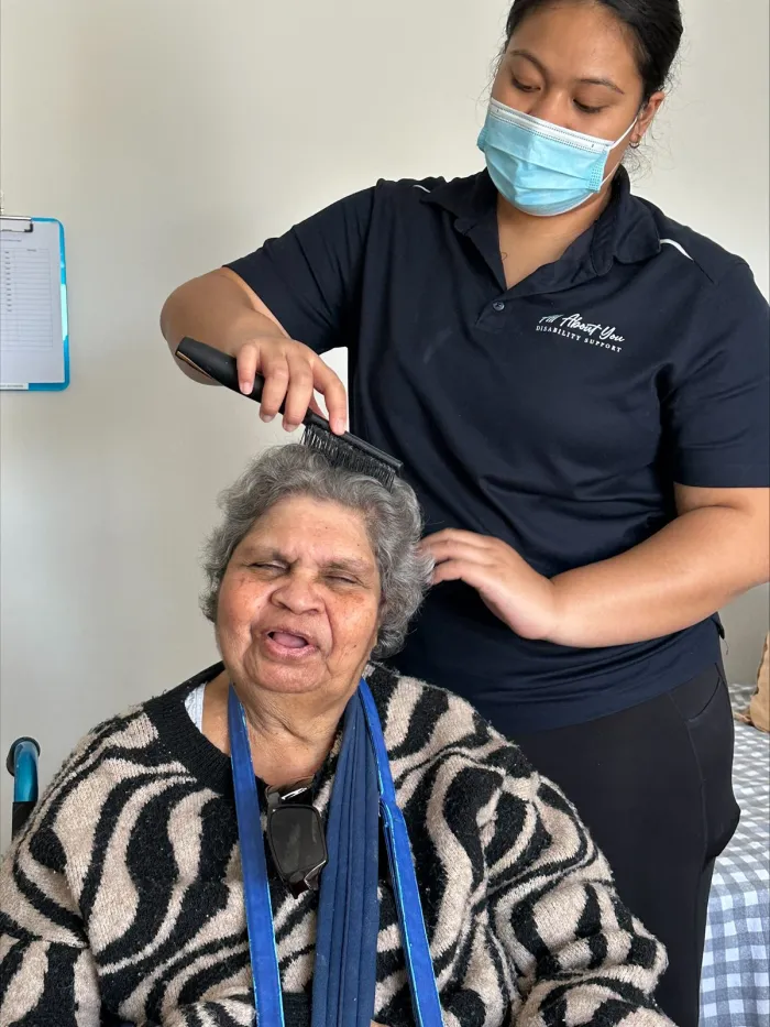 A support worker helping a participant with personal grooming at home