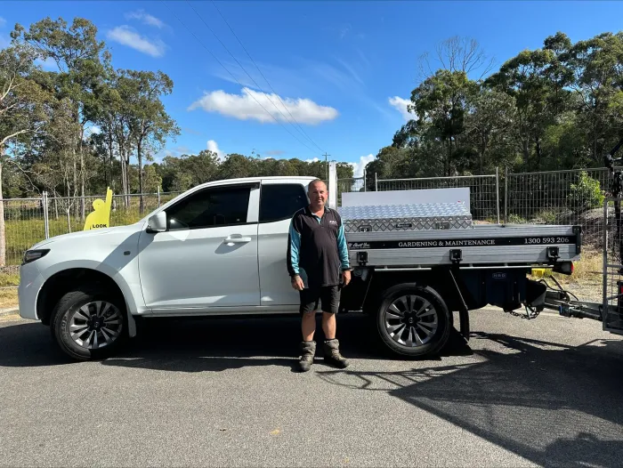 A participant beside the AAYDS gardening and maintenance vehicle