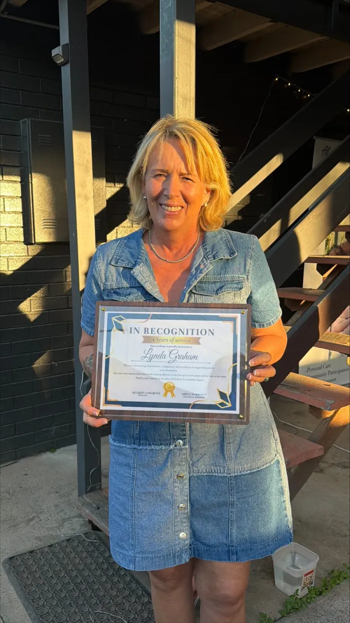 An AAYDS team member with a certificate recognising their years of service